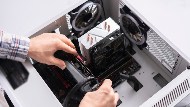 Osoba montira grafičku kartu u otvoreno kućište računara
